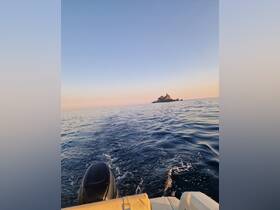 A serene view from a boat heading towards a picturesque island at sunset, showcasing the tranquil beauty of the open water.