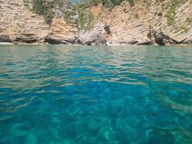 A stunning view of clear turquoise waters and rocky coastline, perfect for showcasing the natural beauty of a boating destination.
