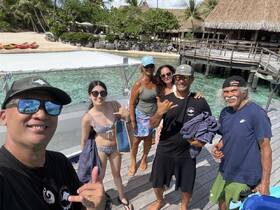 A cheerful group poses for a selfie at a beachside location, ready for a day of snorkeling and fun in the sun.