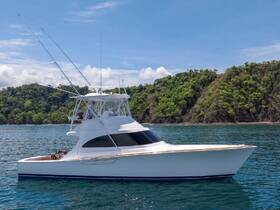 A sleek yacht cruising through clear waters, showcasing its elegant design against a lush green backdrop — perfect for fishing trips or luxury charters.