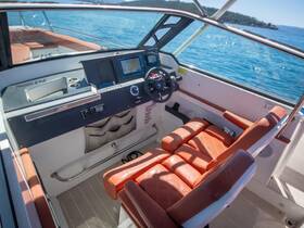 An inviting view of the helm and seating area inside a modern boat, showcasing the sleek design and comfortable layout ideal for navigating the waters.