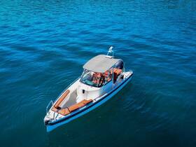 Aerial view of a sleek speedboat cruising through clear blue waters, showcasing its stylish design and comfortable seating.