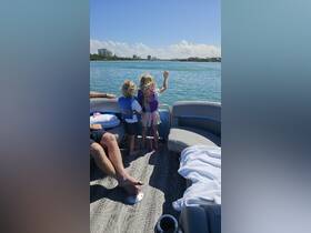 Two children enjoy the view from a boat, showcasing a fun family outing on the water. Perfect for capturing memorable moments during a day of adventure.
