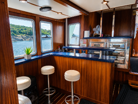 Interior view of a boat's cabin featuring a sleek bar area with seating and large windows showcasing scenic waterfront views — perfect for relaxing on the water.