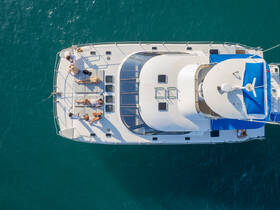 A lively group enjoys sunbathing on the deck of a catamaran, showcasing the perfect atmosphere for relaxation and fun on the water.