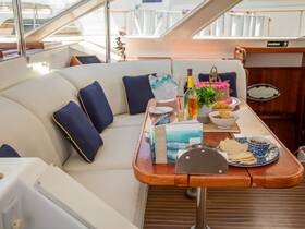 A beautifully arranged dining area inside a boat, featuring a selection of food and drinks, perfect for intimate gatherings or celebrations on the water.