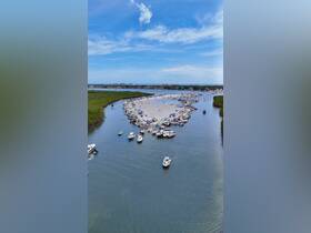 A vibrant scene at a popular sandbar stop, filled with boats and people enjoying a day on the water — perfect for social gatherings and fun in the sun.