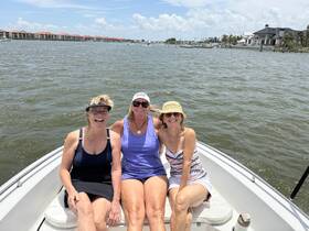 Three friends enjoy a sunny day on the boat, smiling and relaxing on the water — perfect for a fun outing or a day of leisure.