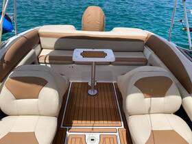 Interior view of a comfortable seating area on a boat, featuring plush cushions and a central table, perfect for relaxing while enjoying the water.