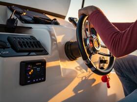 A close-up view of the helm and console of a boat, showcasing the steering wheel and controls, perfect for those looking to navigate the waters.