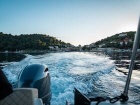 A scenic view from a boat cruising along a picturesque coastline, showcasing the tranquil waters and charming village in the background.