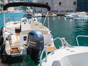 A detailed view of the helm and interior of a sleek boat, showcasing the modern console and comfortable seating, perfect for leisurely outings on the water.