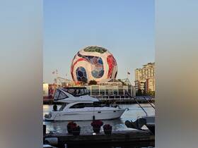 A scenic view of a boat cruising near a vibrant city landmark, showcasing the lively atmosphere of waterfront activities.
