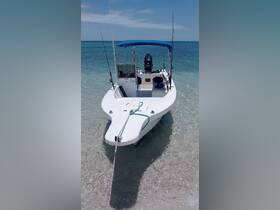A pristine speedboat anchored in shallow waters, showcasing its sleek design and fishing gear, perfect for a day of adventure on the water.
