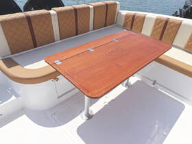 A stylish interior view of a boat's seating area featuring a polished wooden table, perfect for dining or relaxing while on the water.