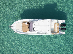An aerial view of a person relaxing on a boat over crystal-clear waters, showcasing the perfect setting for a serene day on the water.