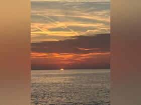 A stunning sunset over calm waters, perfect for capturing the serene beauty of evening boat rides.