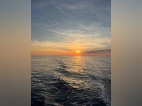 A stunning sunset over the ocean, with gentle waves reflecting the golden hues of the sky — a perfect moment for relaxation and appreciation of nature's beauty.