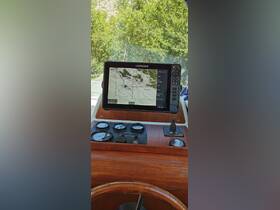 A detailed view of the helm console featuring a Lowrance navigation screen, showcasing essential boating instruments and controls for a smooth sailing experience.