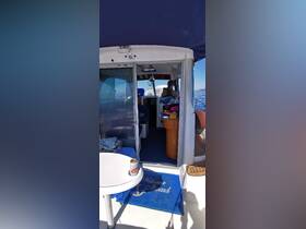 A cozy interior view of a boat's cabin featuring seating and helm, with a guest enjoying the space. Perfect for relaxing while cruising on the water.