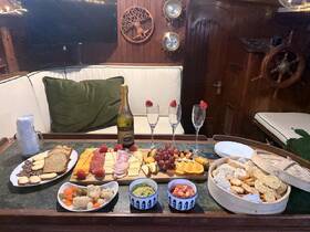 An inviting spread of gourmet snacks and champagne awaits in the cozy interior of a boat, perfect for a relaxing gathering or celebration on the water.