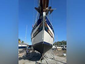 A striking view of the bow of the boat 'Lucinda' in dry dock, showcasing its detailed artwork and structure, with workers present for maintenance.
