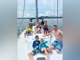 A joyful family enjoys a sailing adventure on a yacht, with kids and adults relaxing together on deck — perfect for creating lasting memories on the water.