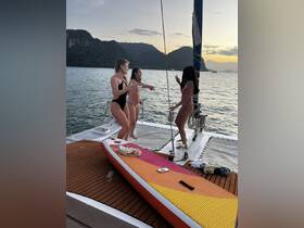 A lively group of friends enjoys a fun moment on a boat at sunset, showcasing the perfect atmosphere for a party on the water.