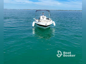 A sleek speedboat navigates through clear turquoise waters, showcasing its stylish design and perfect for a day of adventure on the water.