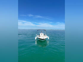 A sleek speedboat is captured from the front, cruising through clear turquoise waters under a bright blue sky — perfect for a day of adventure on the water.