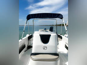 A clean and modern helm view of a boat's interior, showcasing the console and seating area, perfect for navigating serene waters.
