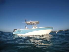 A sleek speedboat named 'Curate' glides through clear waters, showcasing its stylish design and fishing gear — perfect for adventurous outings on the sea.