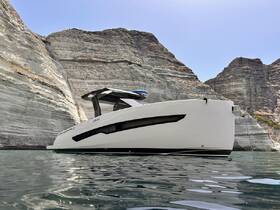 A sleek yacht is showcased against a stunning backdrop of towering cliffs, highlighting its elegant design and the serene waters it navigates.