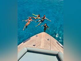 A group of friends enjoys a refreshing swim in crystal-clear waters, showcasing the perfect summer day on the water.
