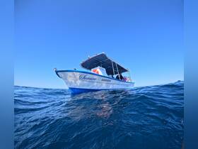 A striking view of the 'Sorairo' boat cruising through clear waters under a bright blue sky, showcasing its sleek design and readiness for adventure.