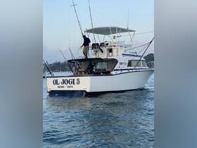 The fishing boat 'OL JOGI 3' is seen underway with crew members preparing for a day on the water, showcasing the excitement of deep-sea fishing adventures in Watamu, Kenya.