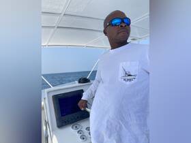 A skilled captain navigates the helm of a boat, showcasing the console and instruments essential for a smooth sailing experience.