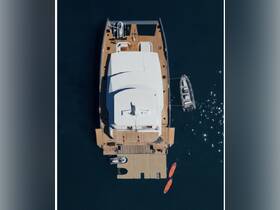 Aerial view of a luxurious yacht docked with kayaks and a small boat nearby, showcasing its spacious deck and elegant design — perfect for upscale boating experiences.