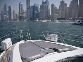 A sleek yacht's bow offers a stunning view of the Dubai skyline, showcasing the perfect blend of luxury and urban scenery on the water.