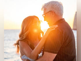 A couple shares a romantic moment at sunset, capturing the essence of love and celebration on the water — perfect for memorable occasions.