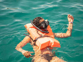 A snorkeler enjoys the vibrant turquoise waters while floating, showcasing the thrill of underwater exploration.