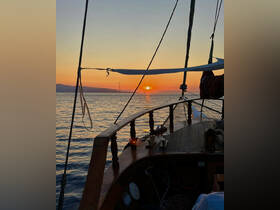 A stunning sunset view from the deck of a sailing boat, capturing the serene beauty of the ocean as the day comes to a close.