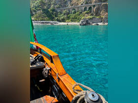 A beautiful view of a wooden boat gliding through crystal-clear waters, showcasing the stunning coastal scenery and vibrant colors of the Italian coastline.
