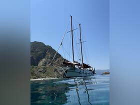 A stunning view of a sailboat anchored near a rocky coastline, showcasing its elegant design against a clear blue sky — perfect for sailing enthusiasts and coastal adventures.