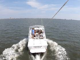 A group enjoys a sunny day cruising on the 'KNOTTED UP' boat in Ocean City, MD, showcasing the perfect blend of relaxation and adventure on the water.