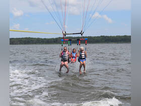 A family enjoys an exhilarating parasailing adventure over the water, capturing the thrill of summer fun and bonding moments.