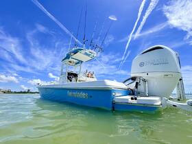 A stunning view of an Everglades speedboat gliding through clear waters under a bright blue sky, showcasing its sleek design and fishing gear.