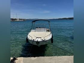 A sleek speedboat docked in clear turquoise waters, showcasing its elegant design against a picturesque coastal backdrop.