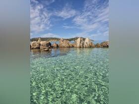 A stunning view of rocky formations emerging from crystal-clear waters, set against a picturesque island backdrop — perfect for showcasing the beauty of coastal destinations.