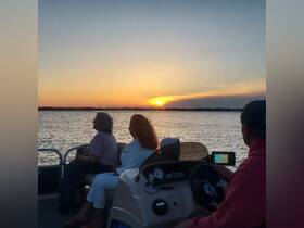 A serene sunset cruise with friends on a boat, capturing the beauty of the evening sky and the joy of relaxation on the water.